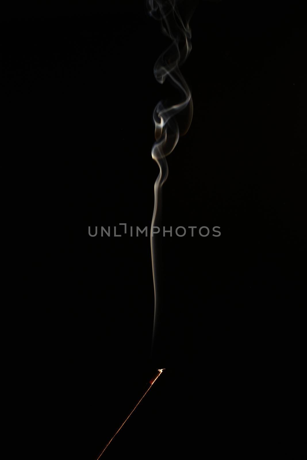 smoldering aromatic stick in the dark, a lot of smoke