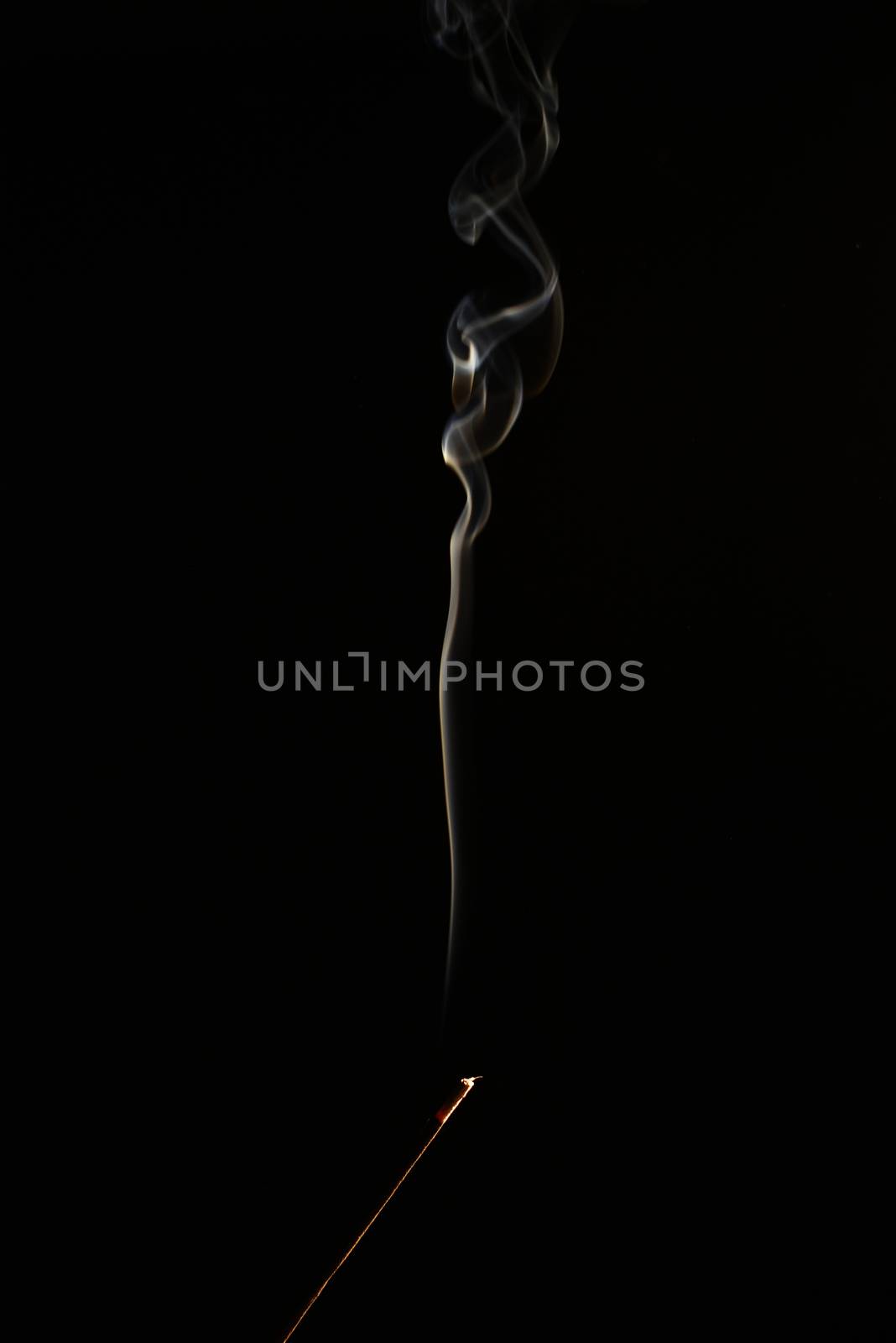 smoldering aromatic stick in the dark, a lot of smoke