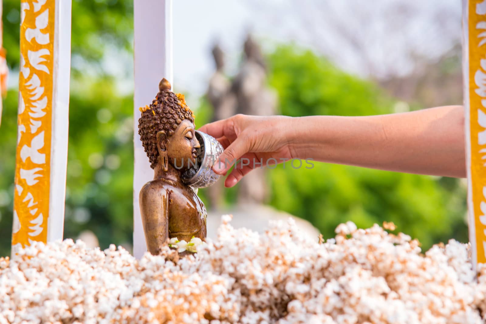 People pour water over Buddha statues during the Songkran Days or traditional Thai New Year.