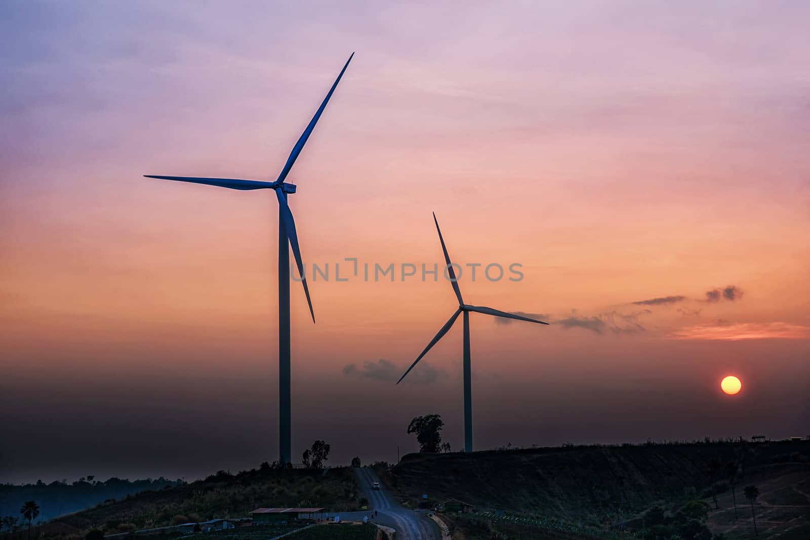 Wind Turbines over a sunset background. by NuwatPhoto