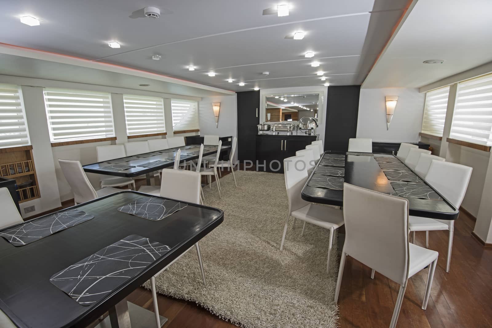 Interior of large salon dining area of luxury motor yacht by paulvinten