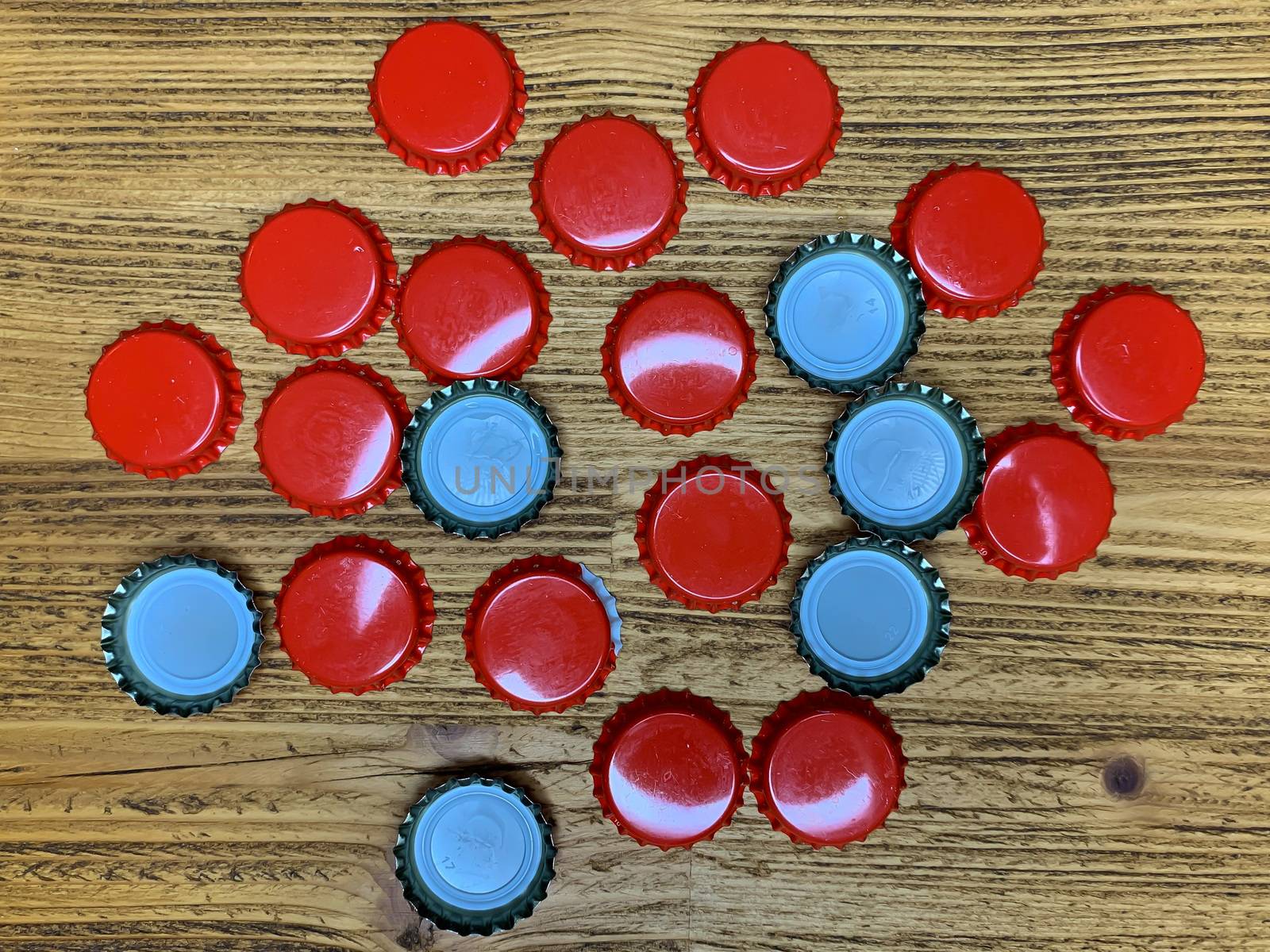 Many red beer lids, bottle corks tops on a wooden texture, top view horizontal stock image