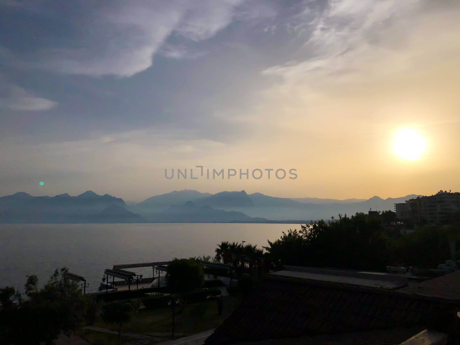 Beautiful summer sunset sunrise over Mediterranean sea with mountains silhouettes. Horizontal stock image.