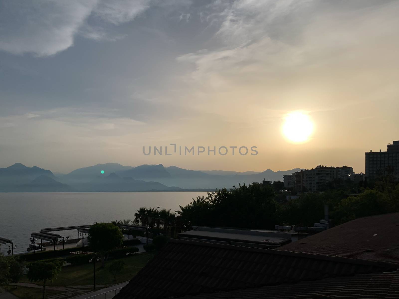 Beautiful summer sunset sunrise over Mediterranean sea with mountains silhouettes. Horizontal stock image.