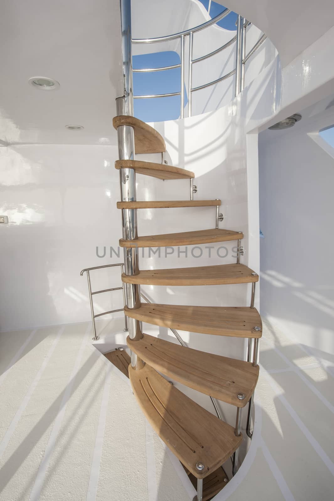 Wooden curved staircase on sundeck area of large luxury motor yacht