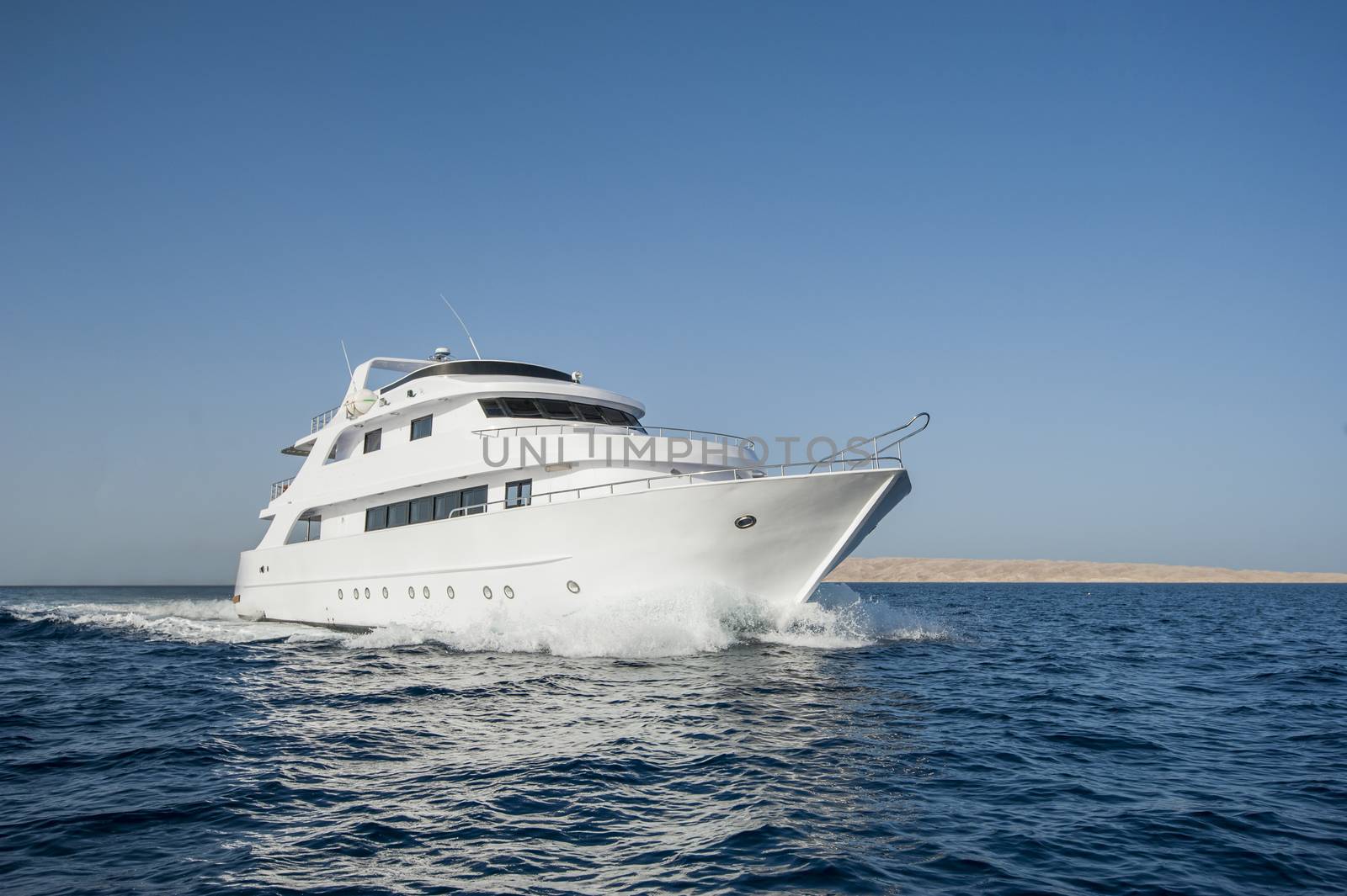 Large luxury motor yacht under way sailing out at sea