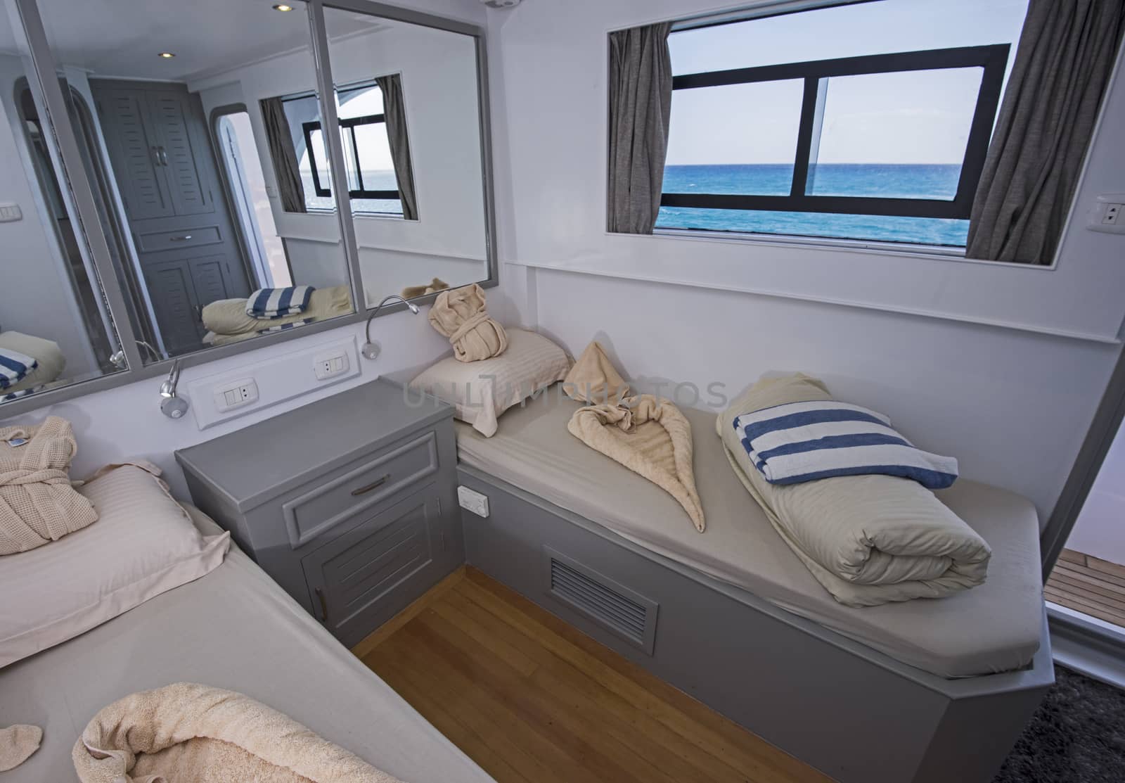 Twin beds in cabin of a luxury private motor yacht with sea view
