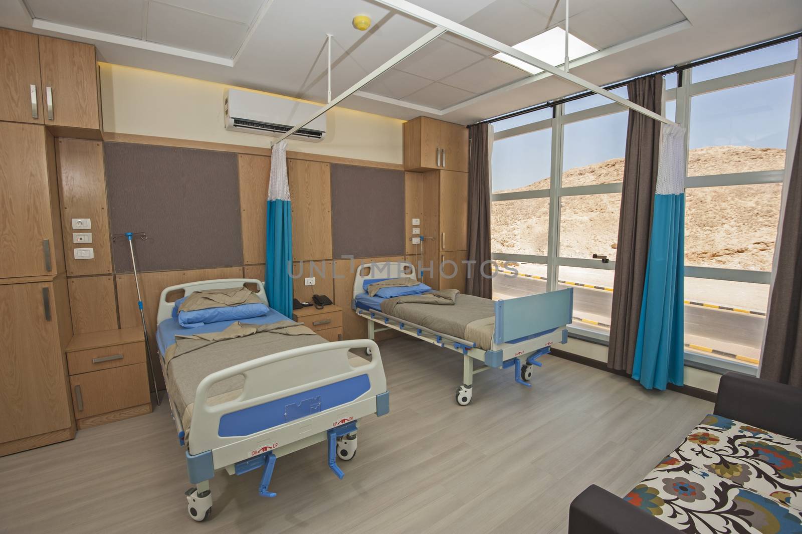 Hospital beds in a private hospital ward with sofa