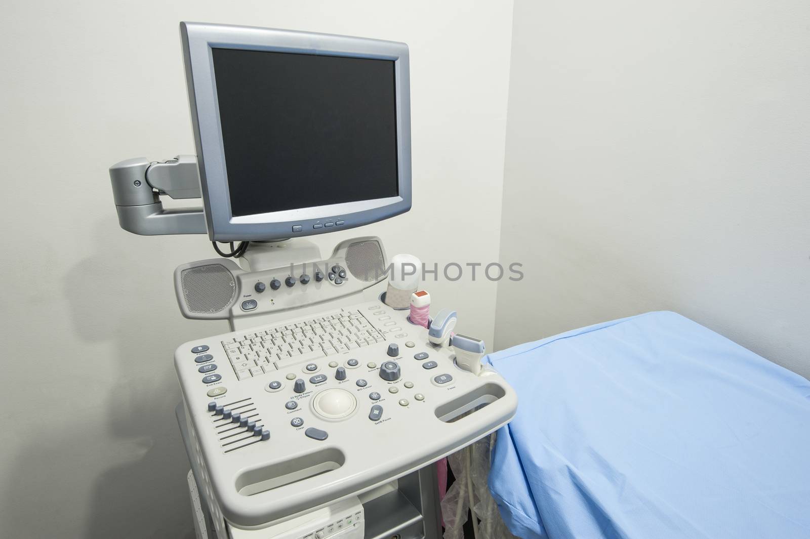 Examination bed with ultrasound scanner machine in medical center hospital