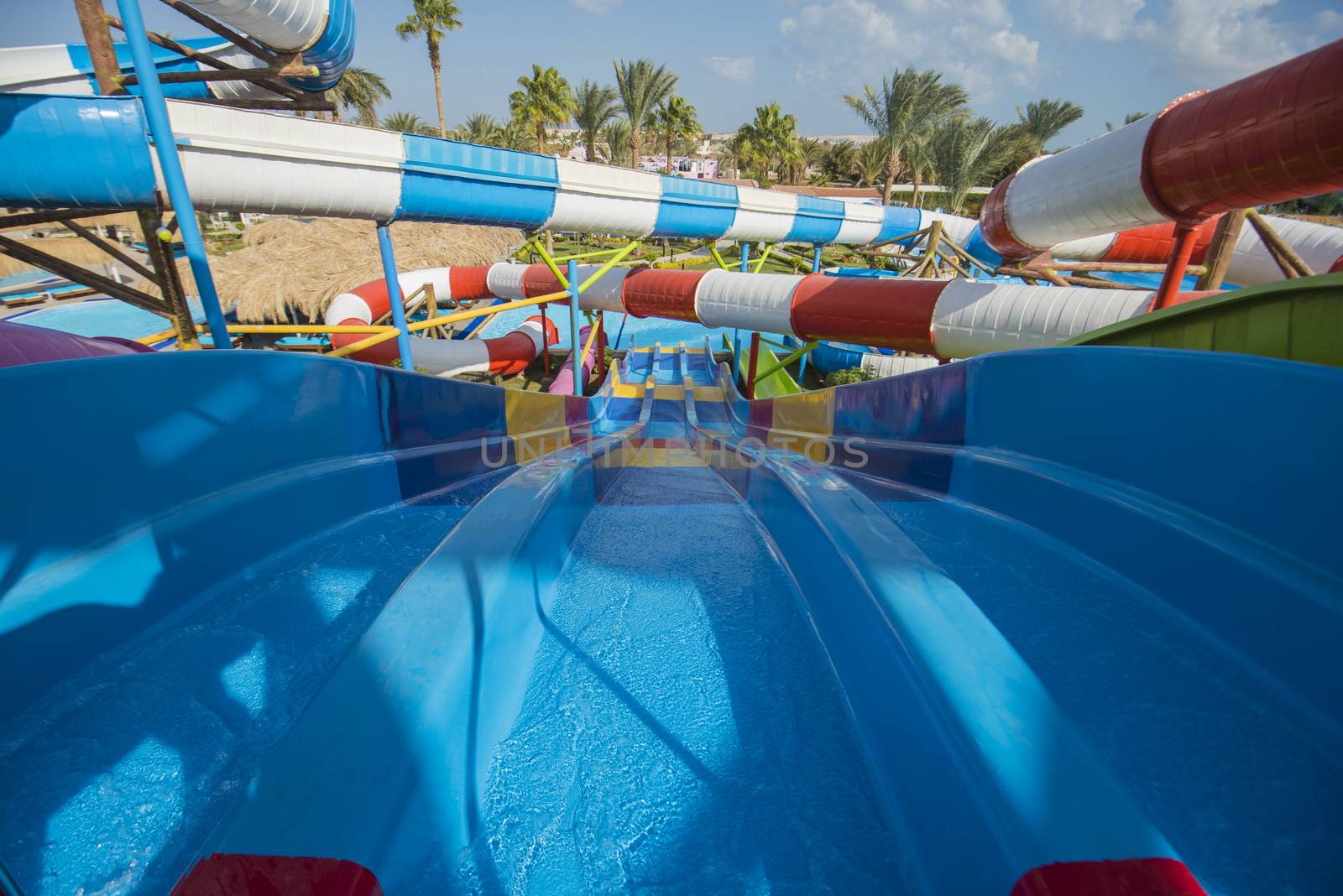 Large swimming pool aqua park water slides at a luxury tropical hotel resort