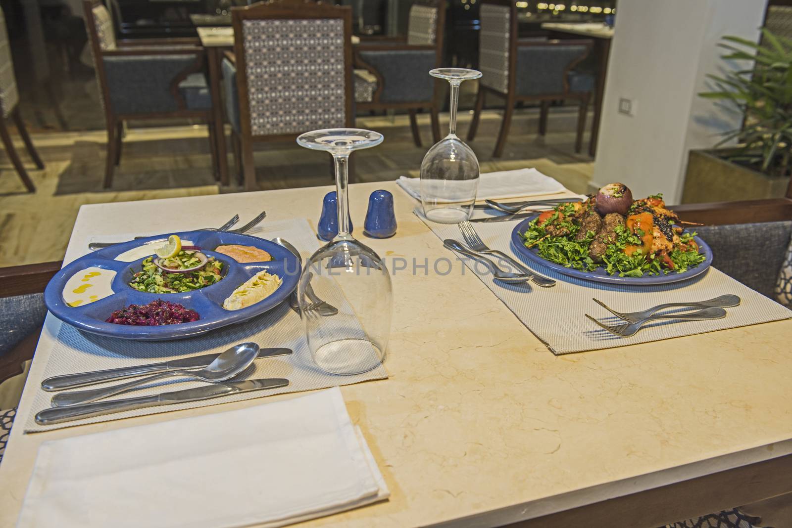 Oriental mixed grill meal and meze salad dish in a la carte hotel restaurant with wine glasses