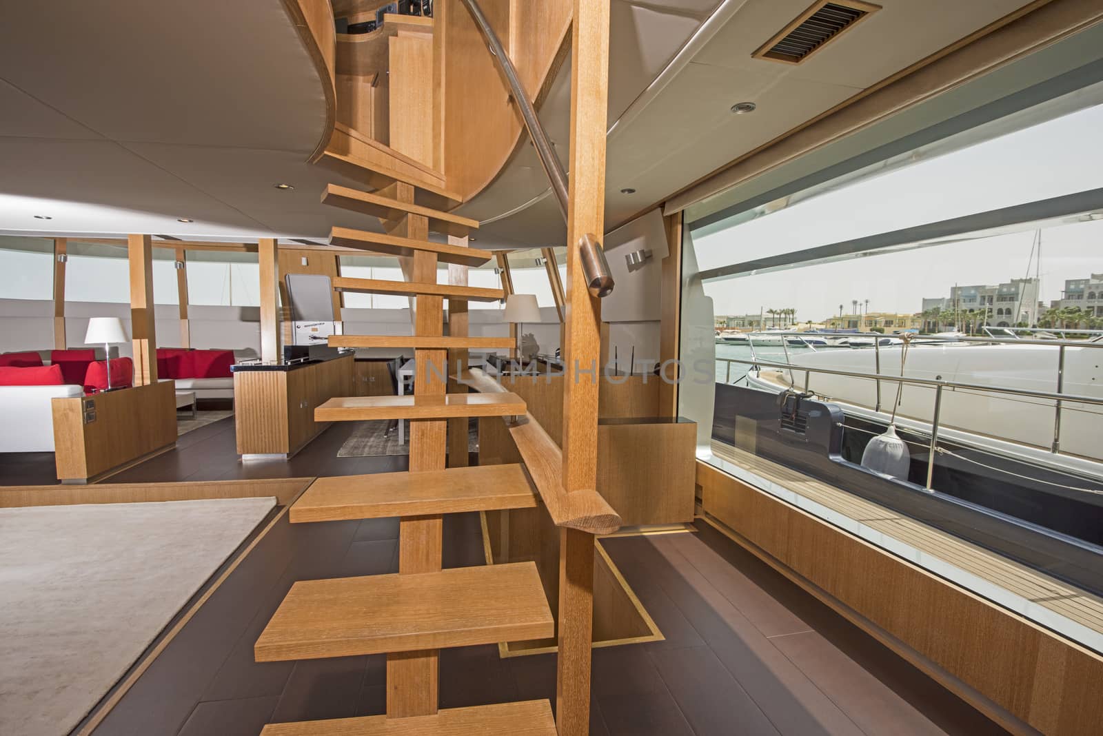 Wooden curved staircase in salon area of large luxury motor yacht