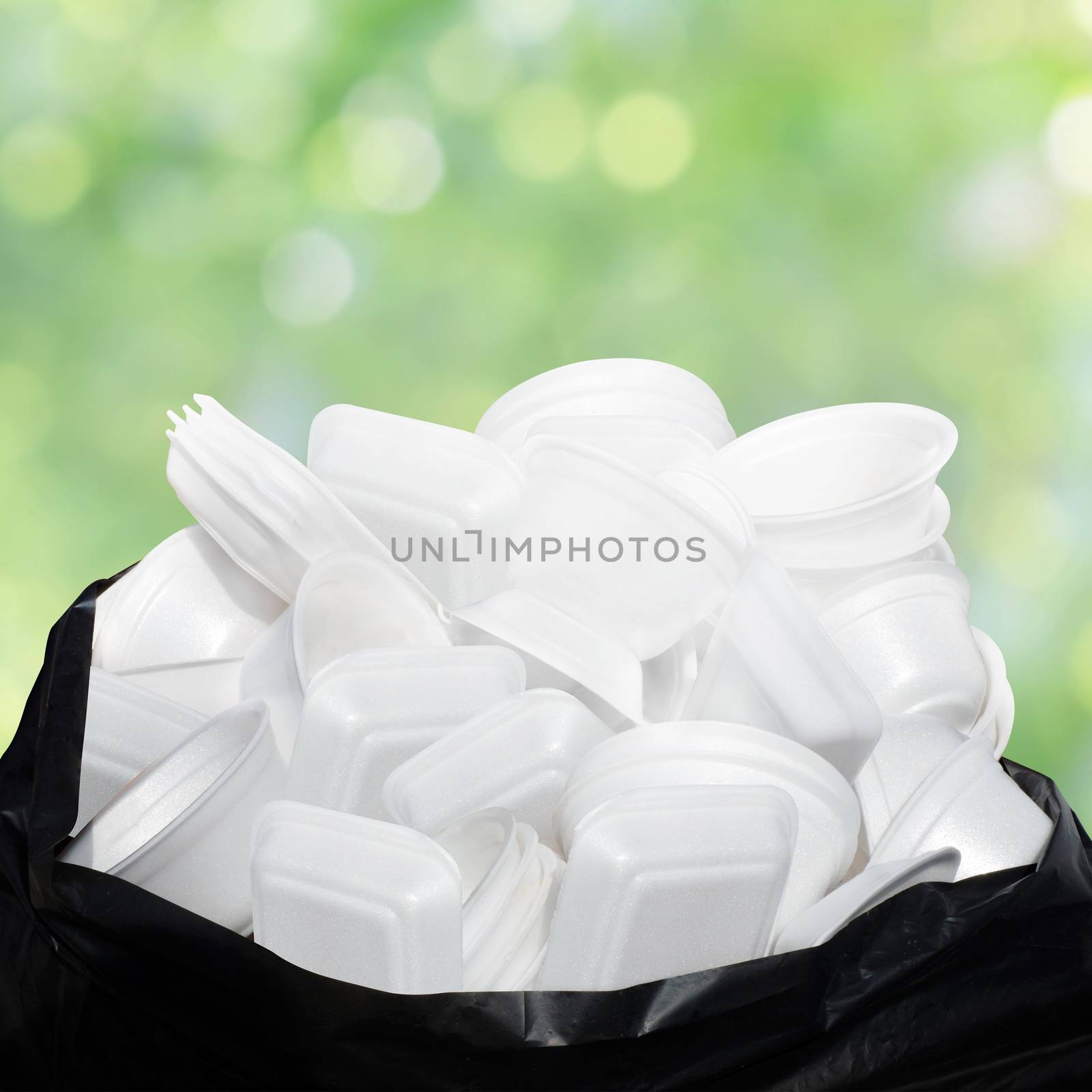 Waste Garbage foam food tray white many pile on the plastic black bag dirty on green nature bokeh background by cgdeaw