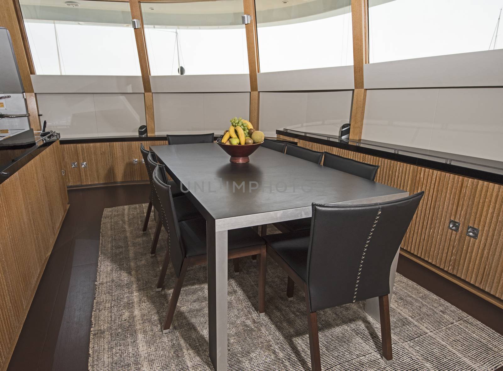 Dining area with table and chairs on large luxury motor yacht