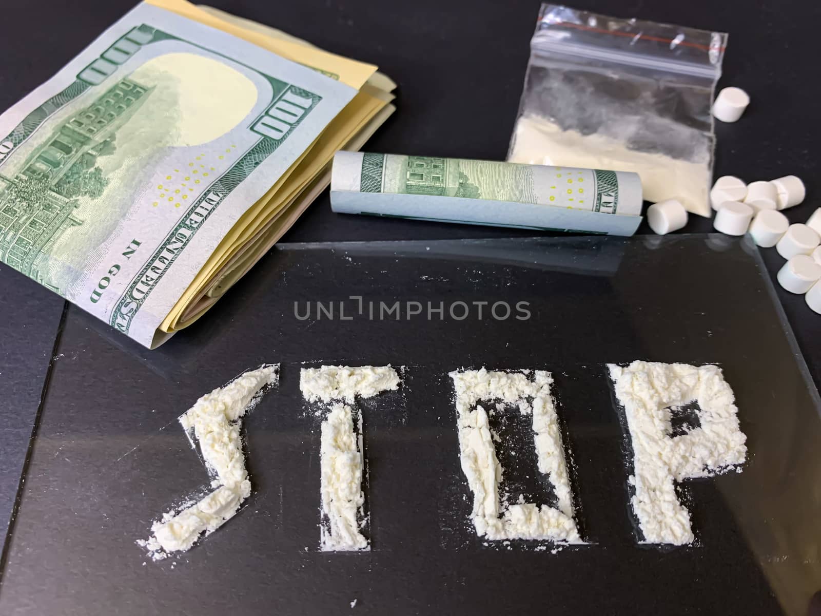 Pills, us dollar banknotes and cocaine  on a gray background. Stop drugs concept. Stock image.