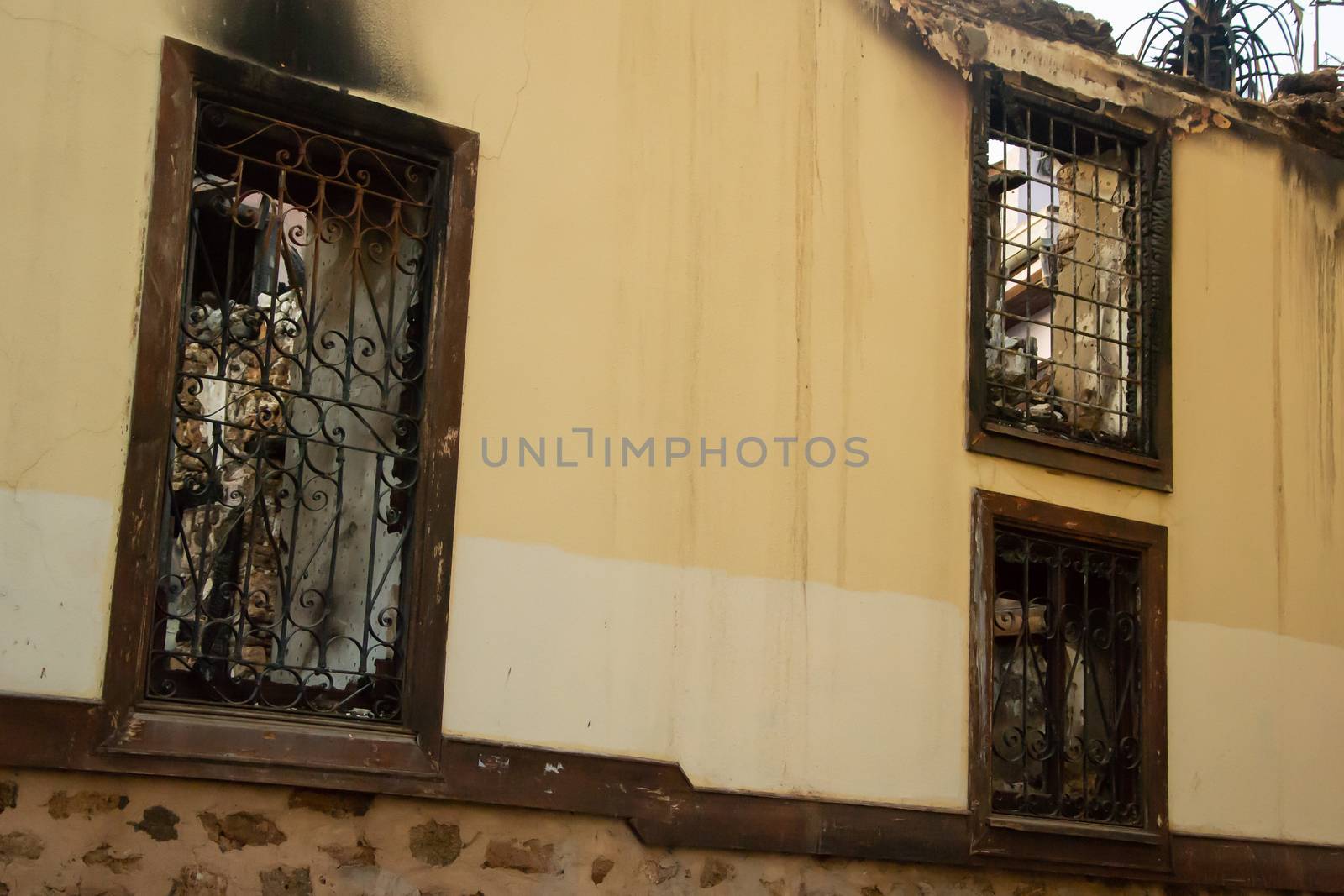 Ruins of burned ancient historical 2 floors house after fire disaster accident in old town of Antalya Kaleici Turkey. Stock image of heaps of ash and arson, collapsed roof and broken windows.