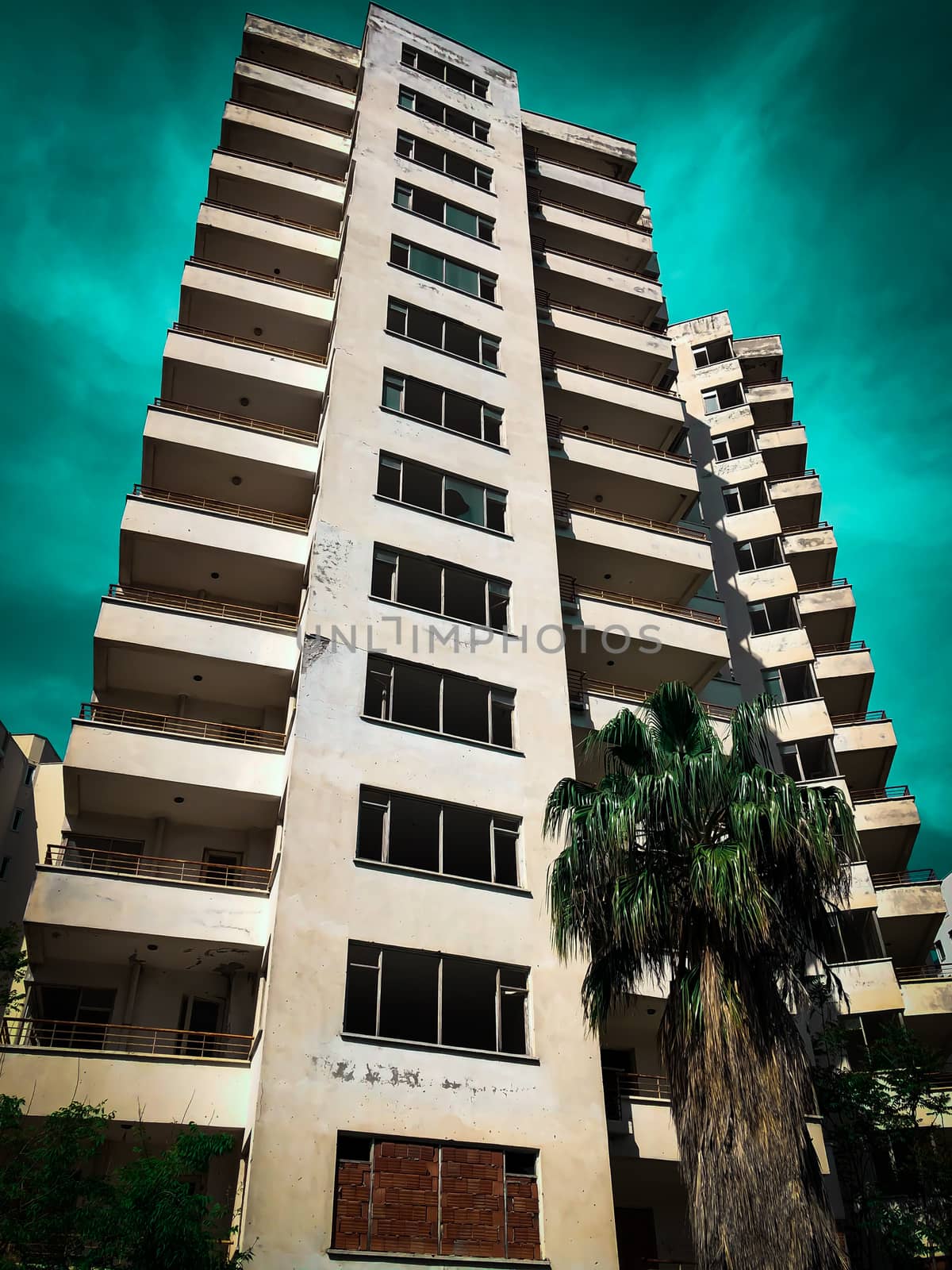 Abandoned high-rise apartment building unfinished construction view from outside on blue sky background