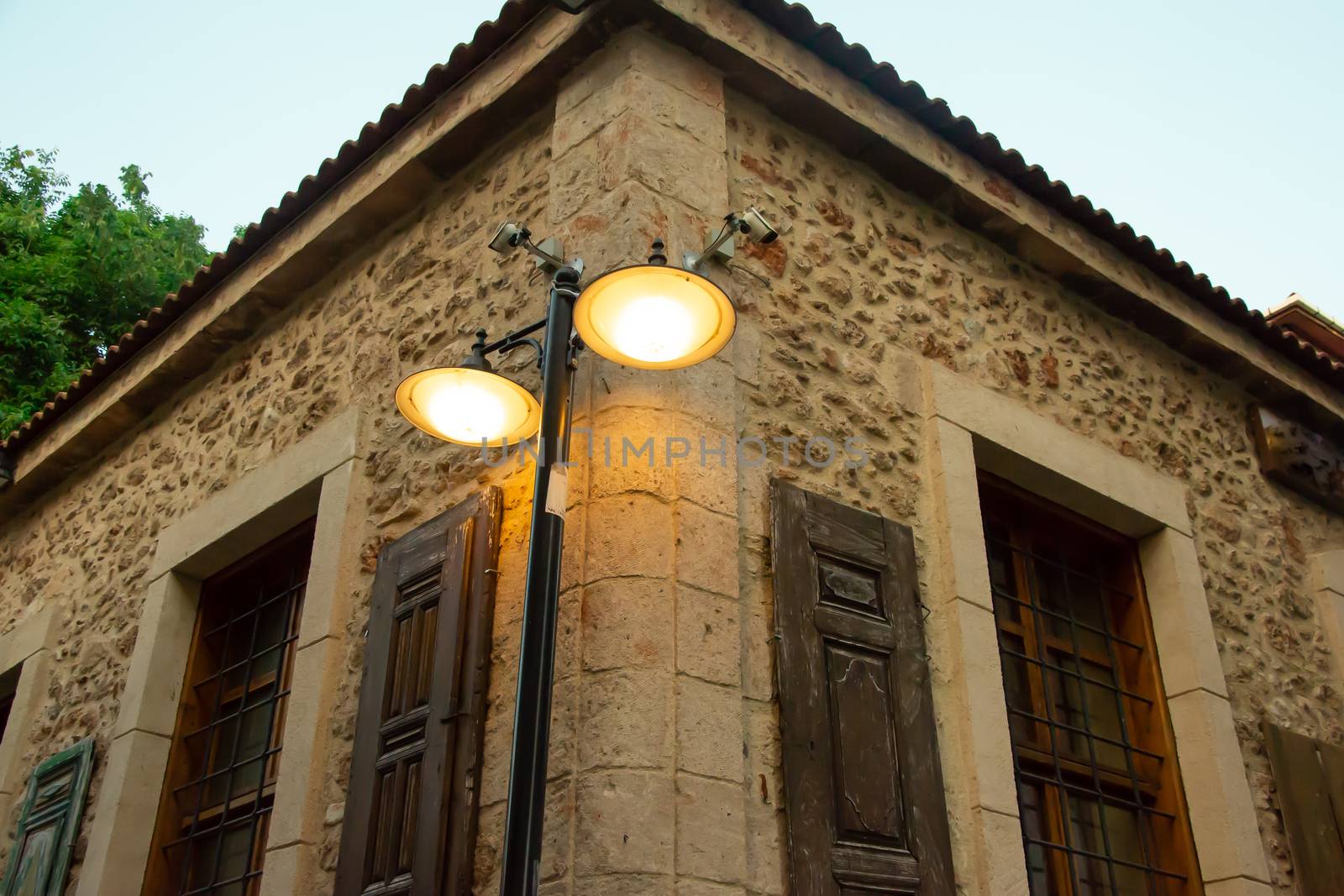 A street light and an old Ottoman time stone house on the streets of Antalya Old Town Kaleici. Stock image.