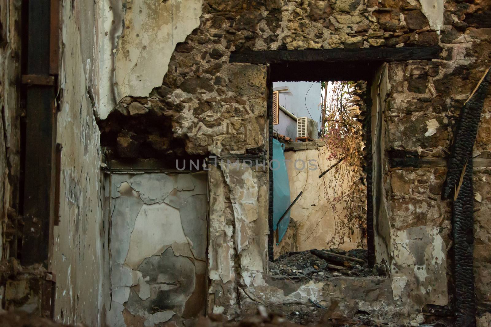 Ruins of burned ancient historical 2 floors house after fire disaster accident in old town of Antalya Kaleici Turkey. Stock image of heaps of ash and arson, collapsed roof and broken windows.