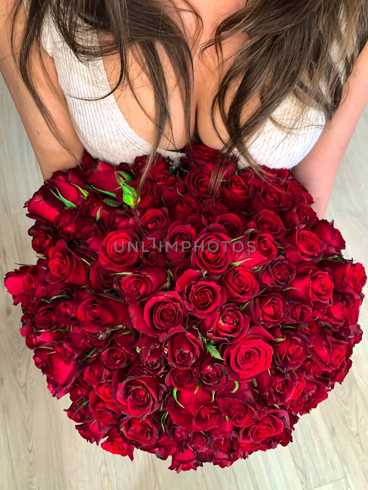 A young girl holding in hands a huge bouquet of 101 wonderful re by AlonaGryadovaya