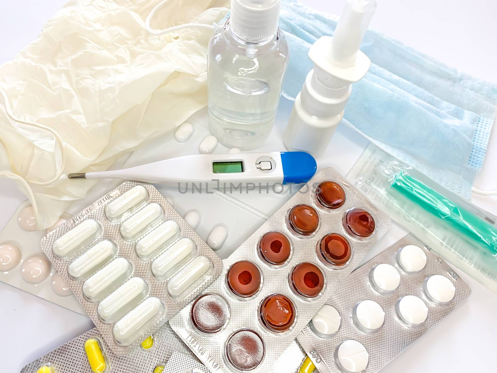 Different medicines: tablets, pills in blister pack, medications drugs, medical gloves, mask, syringe, thermometer, spray, sanitizer on a white background. Horizontal photo