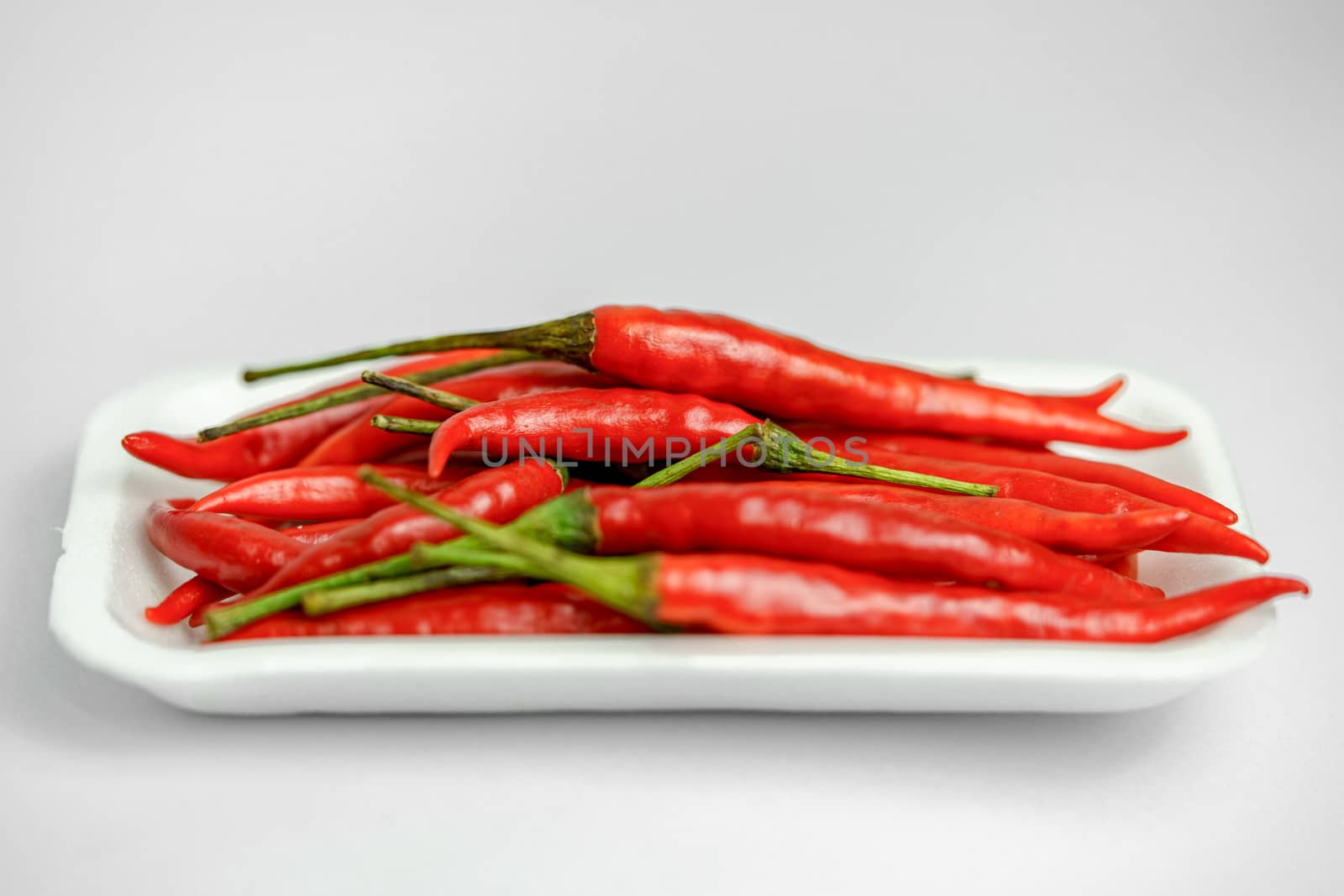 Close-up shot of red peppers on a white background. Fresh food ingredients concept.