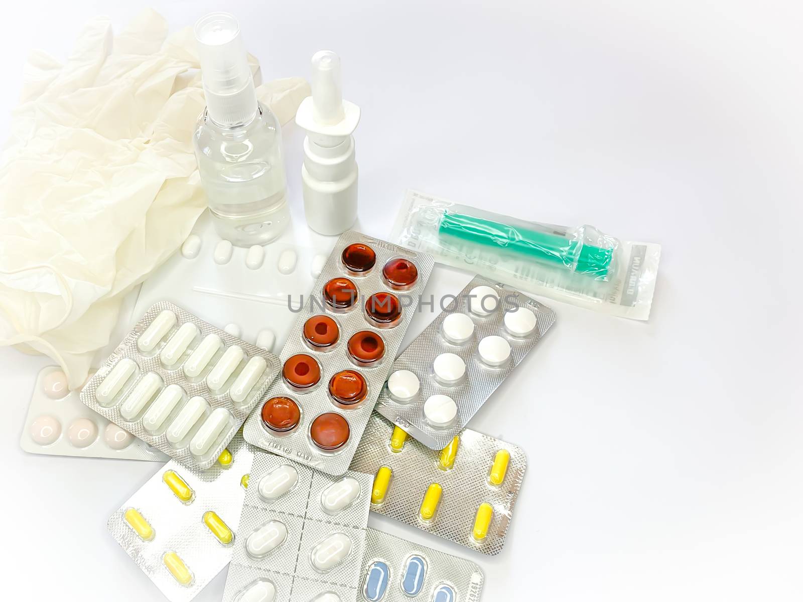 Different medicines: tablets, pills in blister pack, medications drugs, medical gloves, mask, syringe, spray, sanitizer. Close up, space for text. Horizontal image