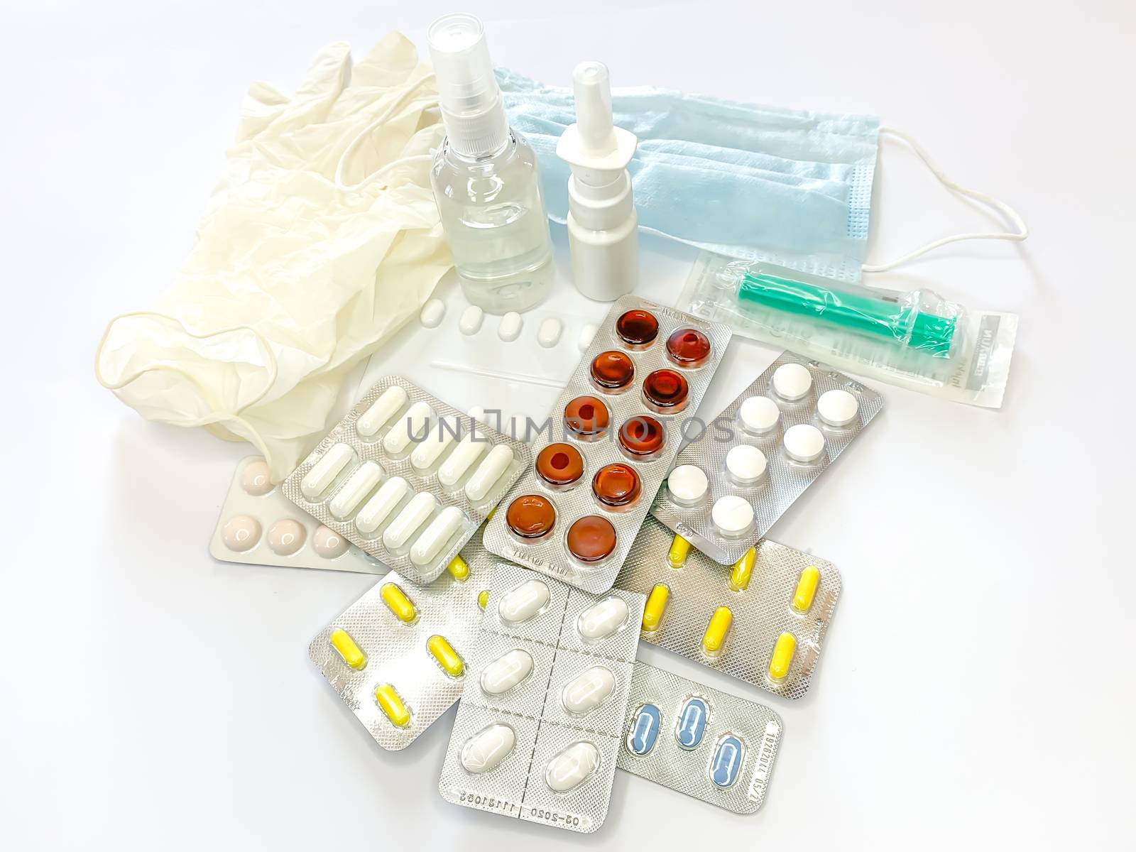 Different medicines: tablets, pills in blister pack, medications drugs, medical gloves, mask, syringe, thermometer, spray, sanitizer on a white background. Horizontal photo