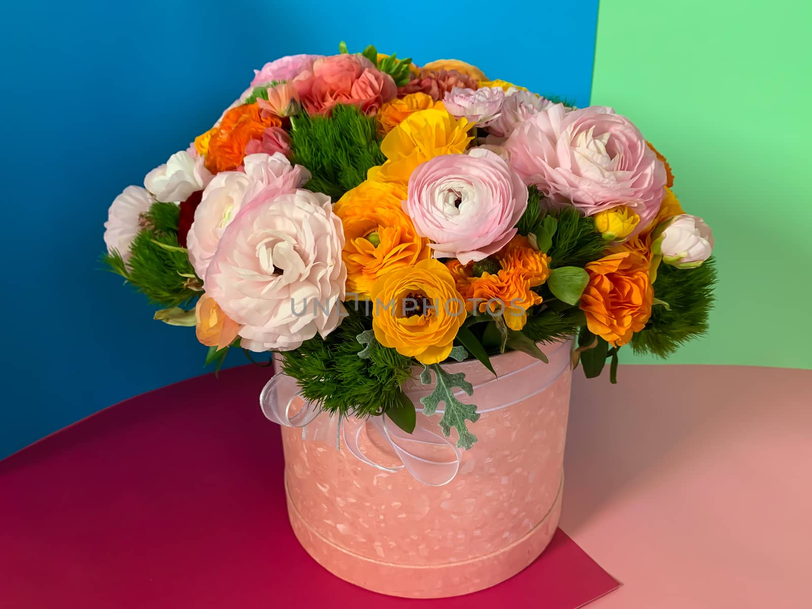 Bright colorful pink yellow orange persian asian buttercup ranunculus asiaticus bouquet fresh flowers in round box