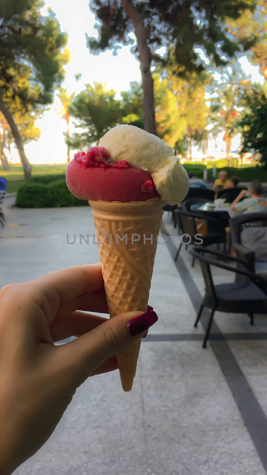Colorful ice cream in a waffle cone in a girl's hand
