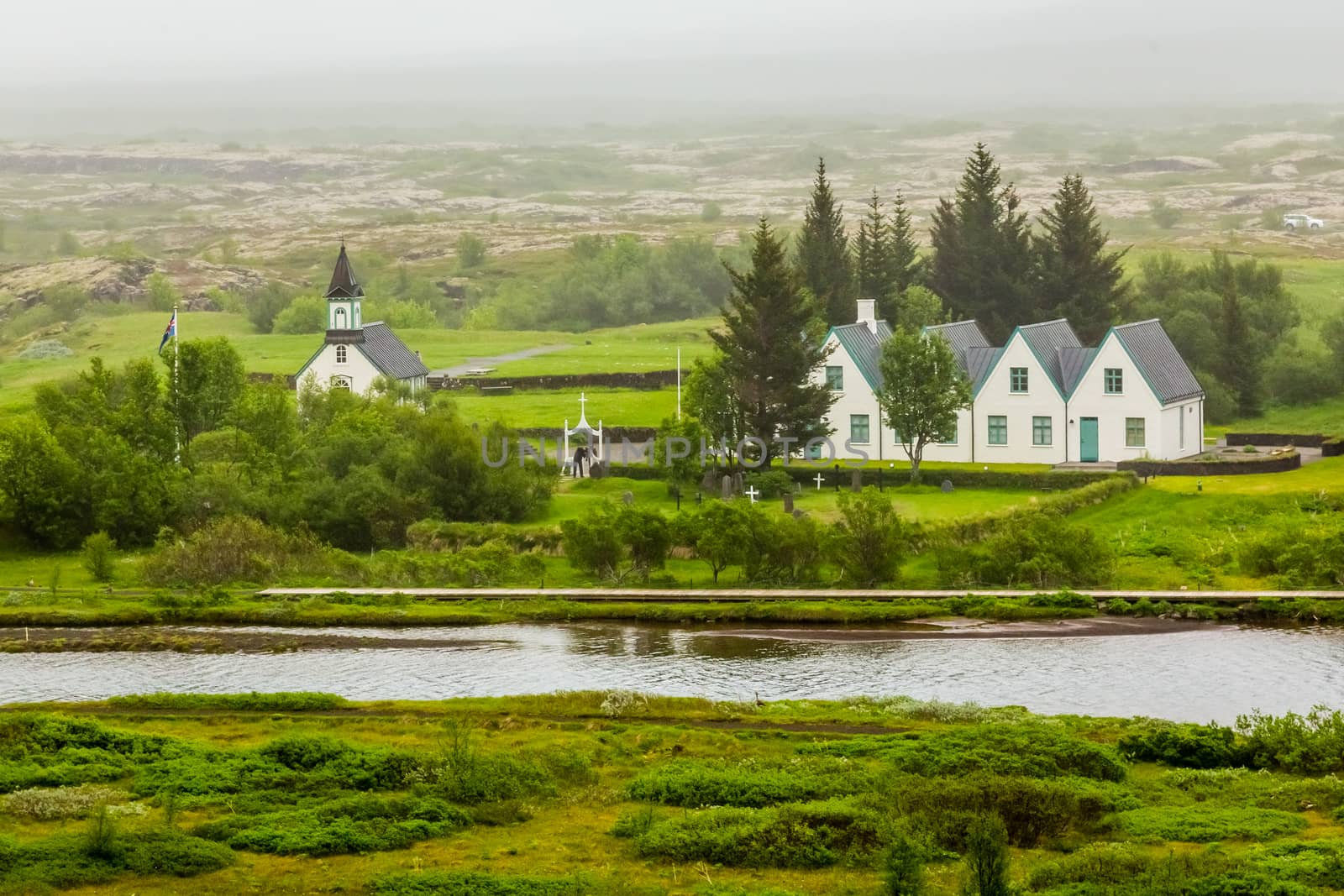 Tingvellir church standing on the river shore along with white houses, Tingvellir National Park, Iceland