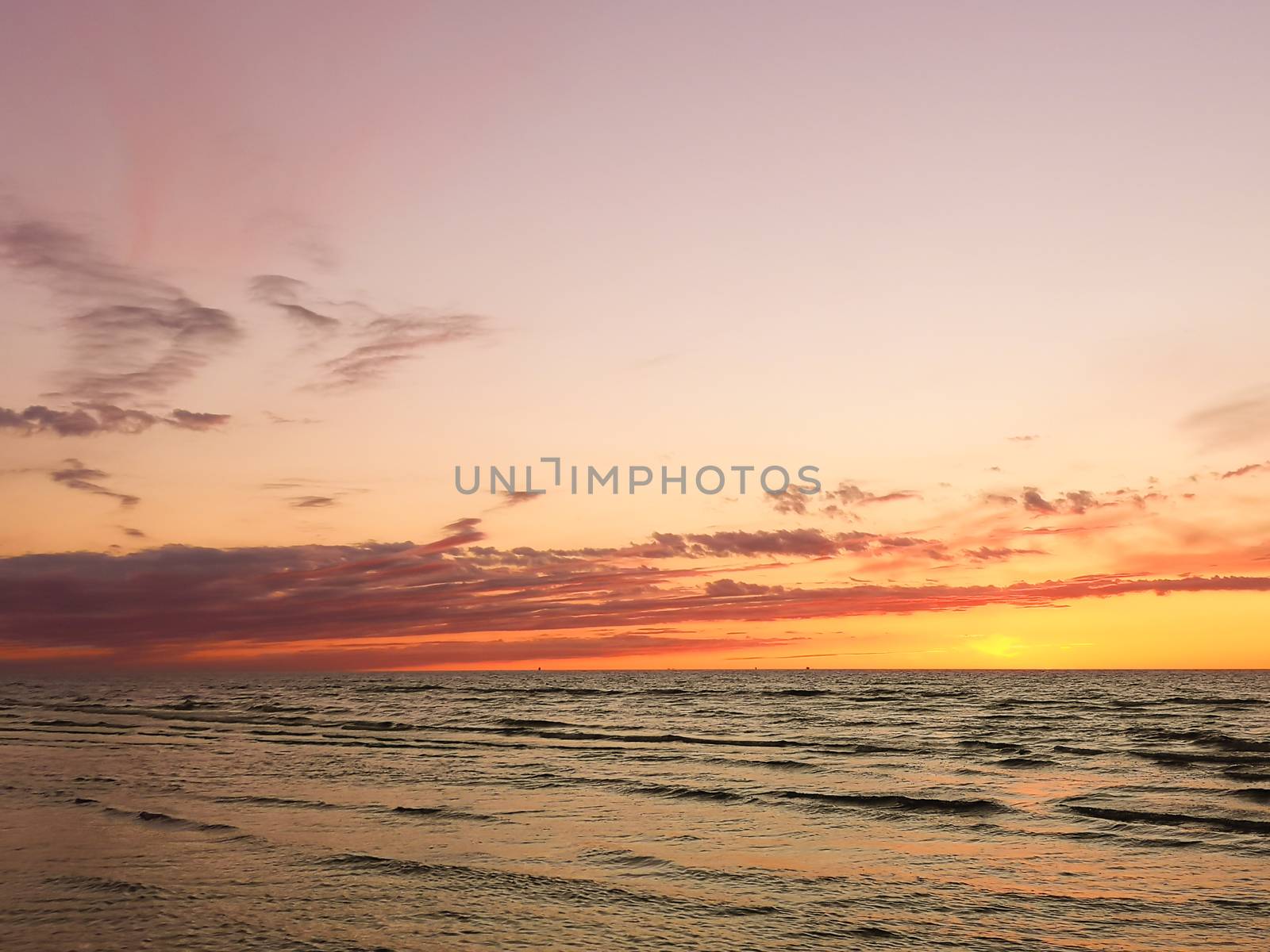 Beautiful colorful sunset at calm Baltic sea. Vertical image