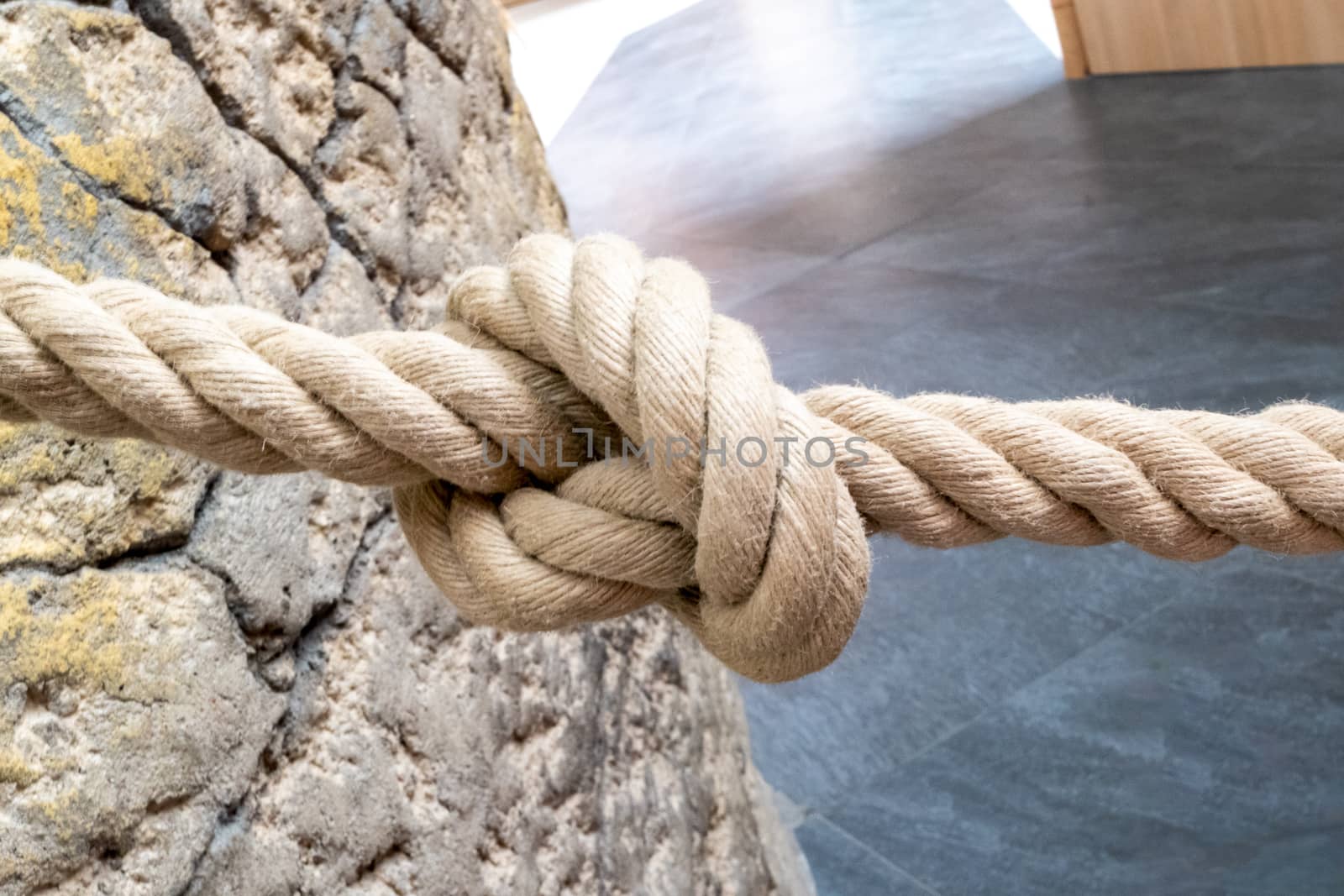 A barrier rope with a knot in the middle by Guinness