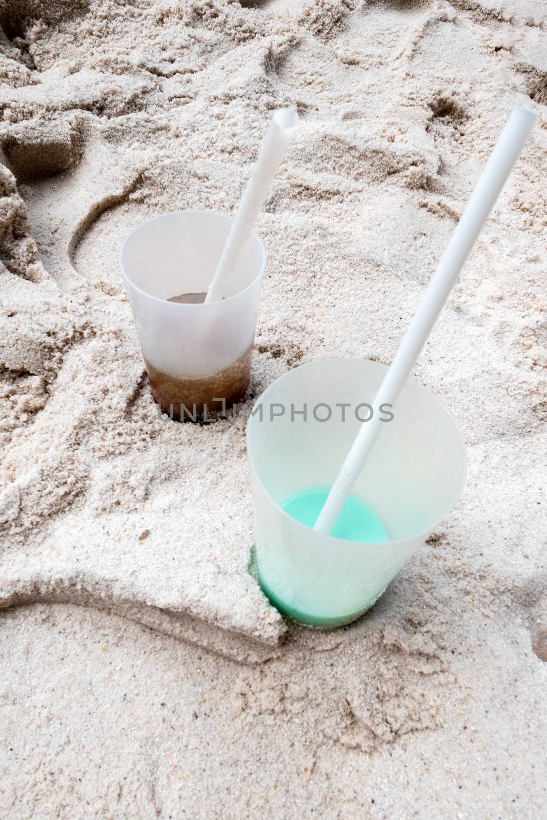 Two cups on the beach by Guinness