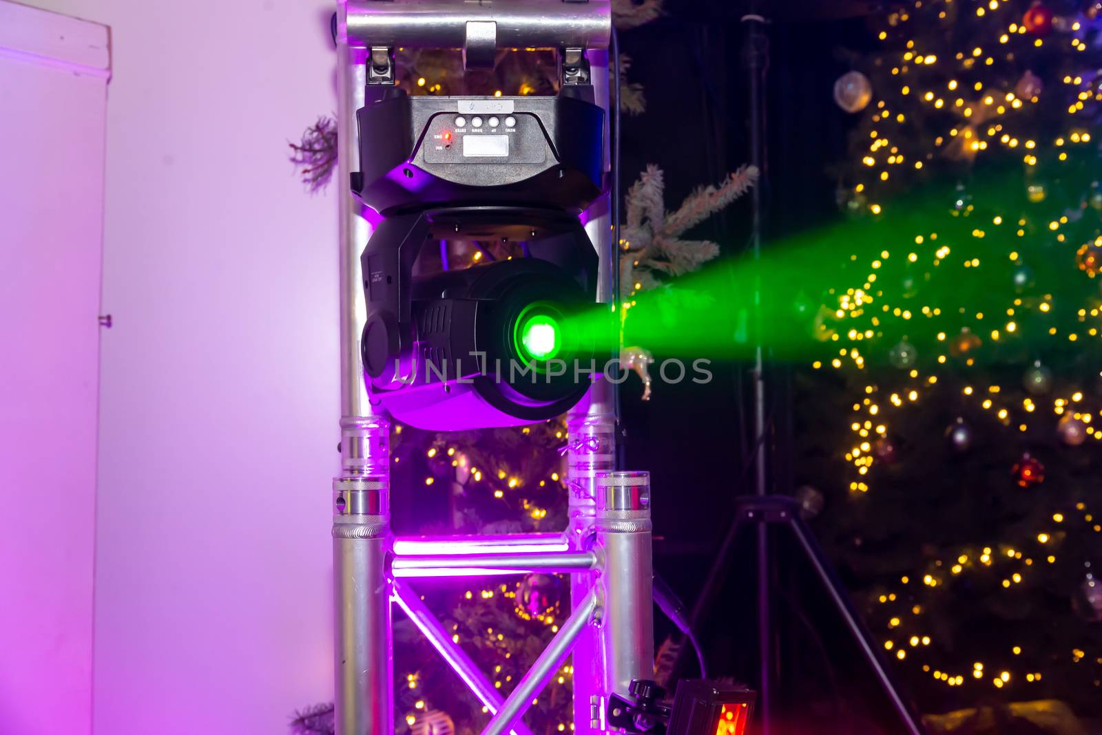 Dallgow-Döberitz, Brandenburg/Germany - 01.01.2020: A head moving spotlight, called moving-head at an event. It emits a clear green beam and is suspended from a truss.