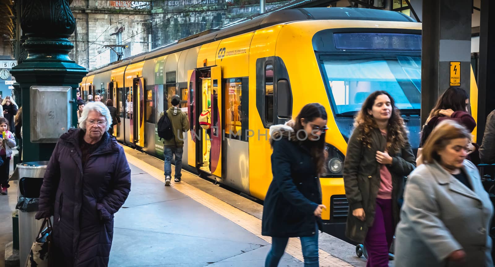 Interior of Porto train station where people walk on the dock by AtlanticEUROSTOXX