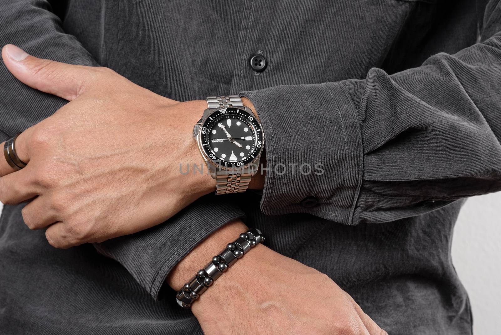 The man posing with dive watch with stainless steel bracelet.