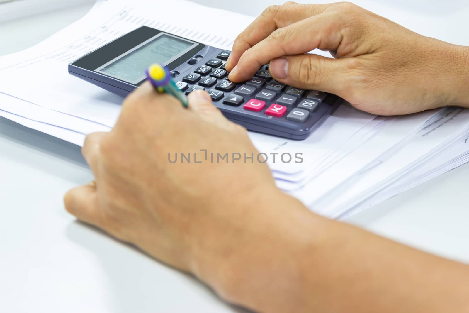 Employees use office calculators with documents of income, expenses, concept of life at work.