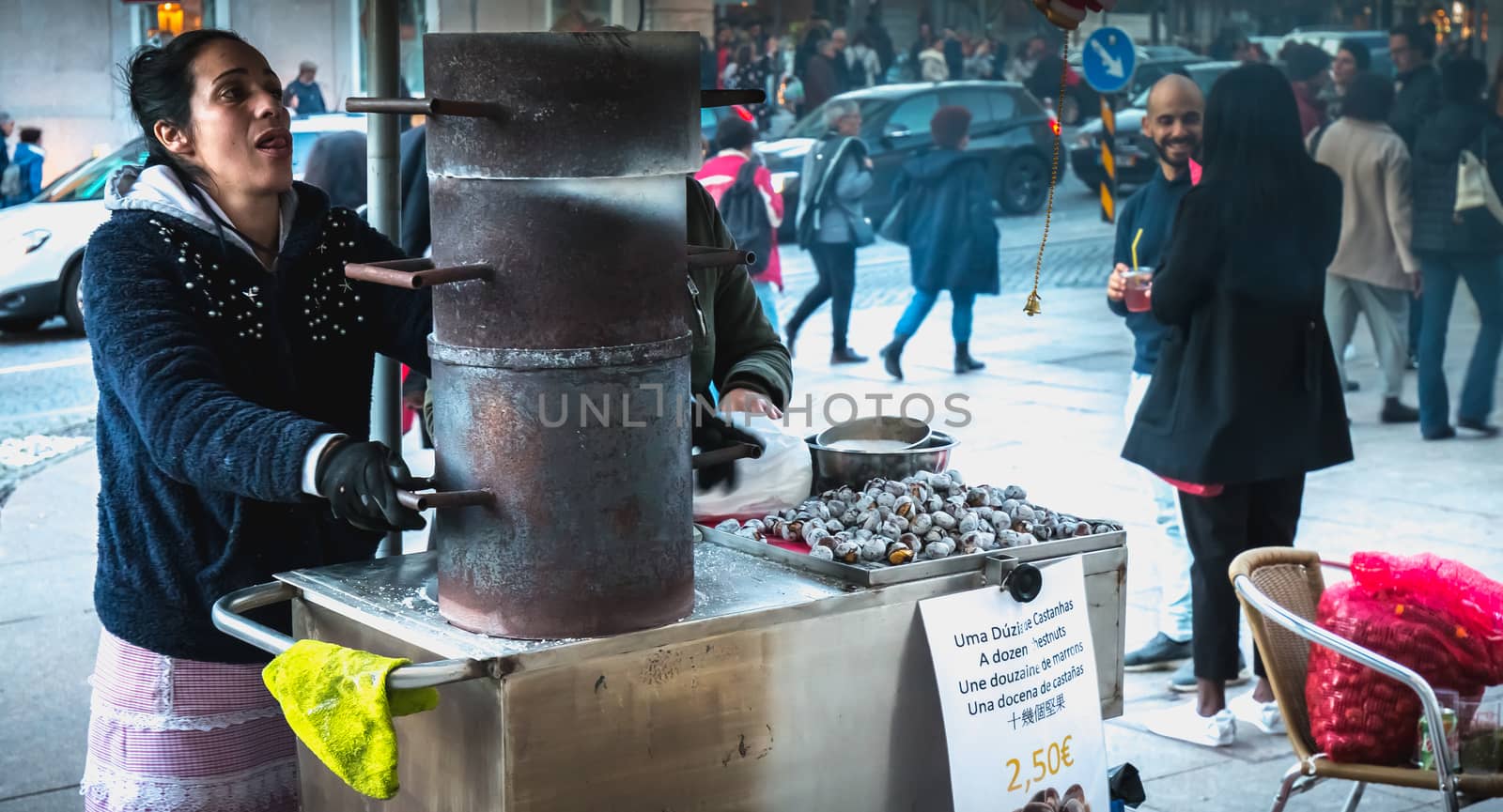 Porto, Portugal - 30 November 2018: Street vendors of roasted chestnuts in front of Sao Bento station in the city center on a fall day