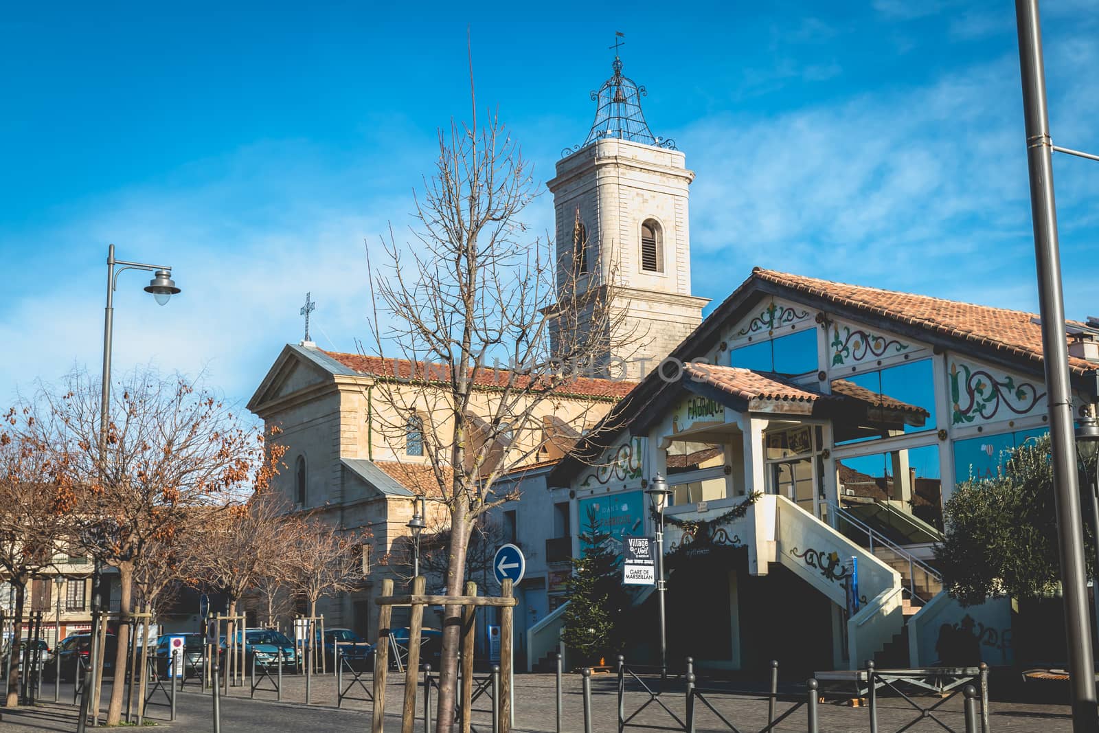 Marseillan, France - December 30, 2018: architectural detail of the Saint Jean-Baptiste church and the La Fabrique media library in the historic city center on a winter day