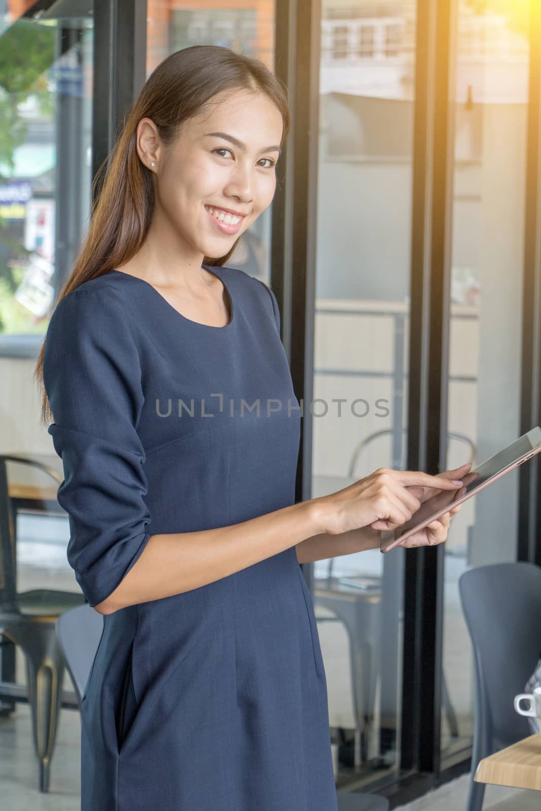 Asian business woman standing to drink coffee, In front of a coffee shop.