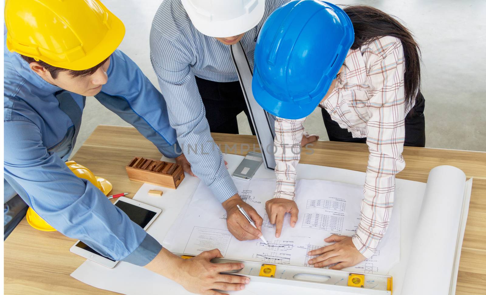 A group of engineers are looking at a blueprint for construction on the table. Engineering concept.