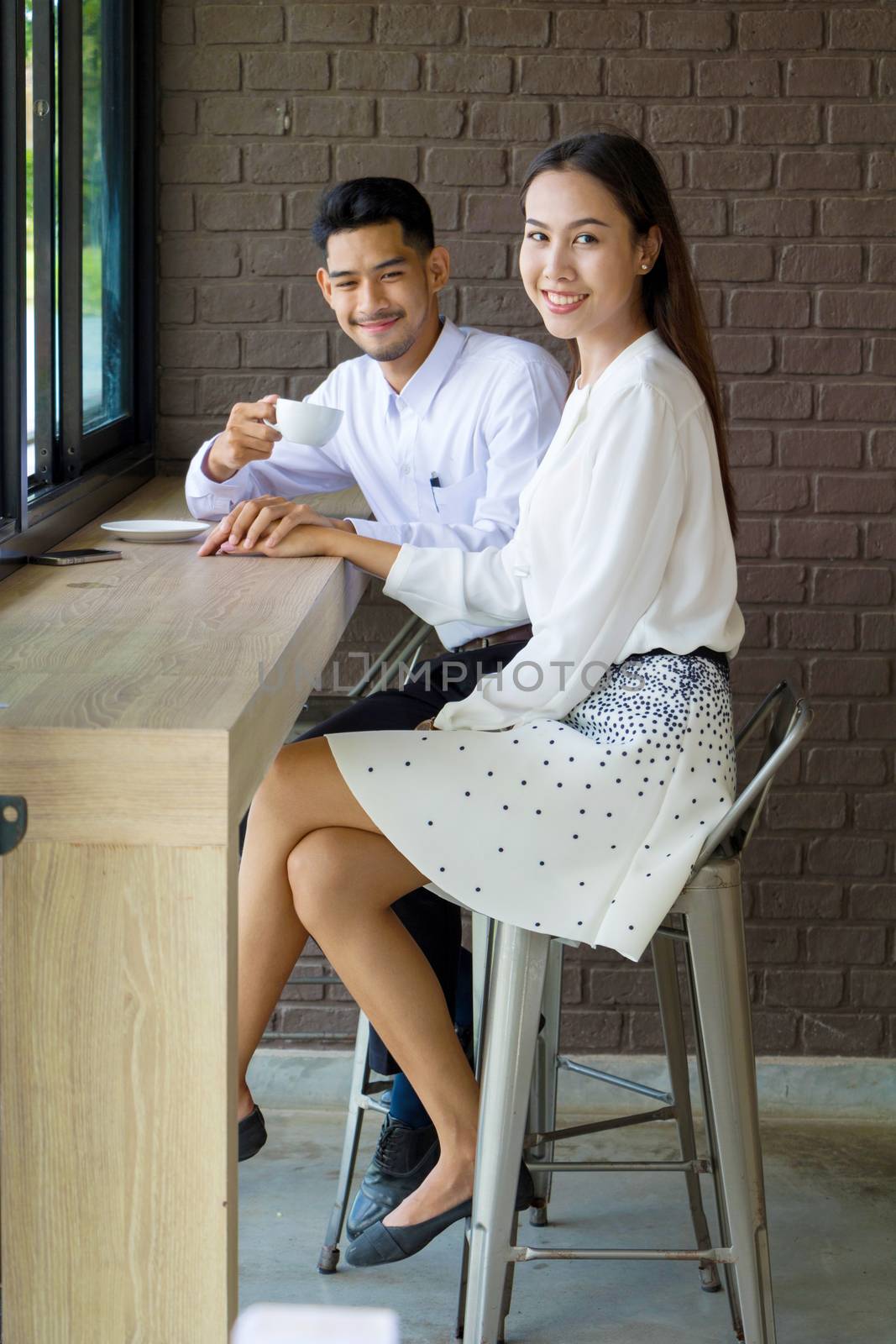 Asian young couple in love at a coffee shop, they are smile. Conception in coffee shop.