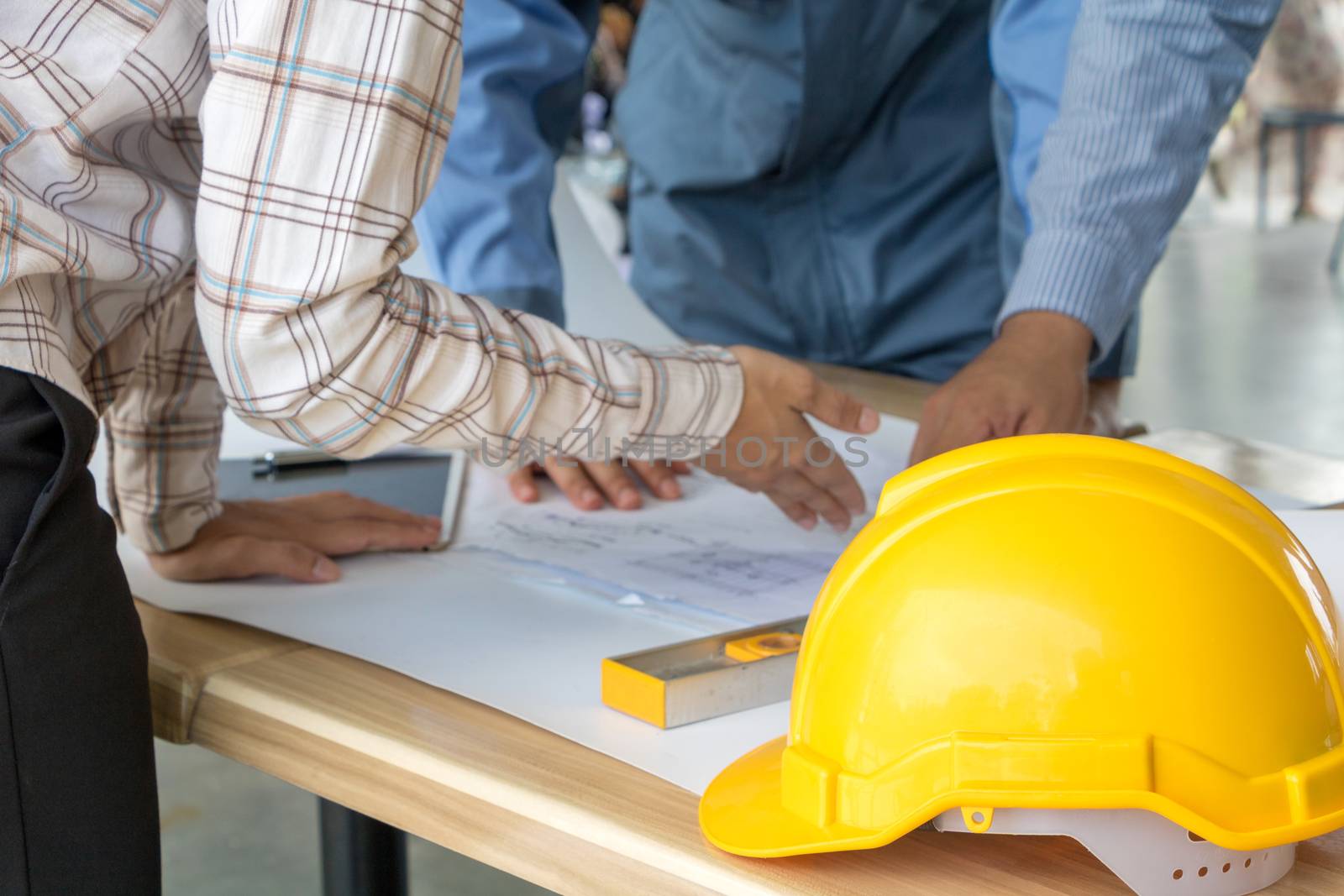 A group of engineers are looking at a blueprint for construction on the table. Engineering concept.