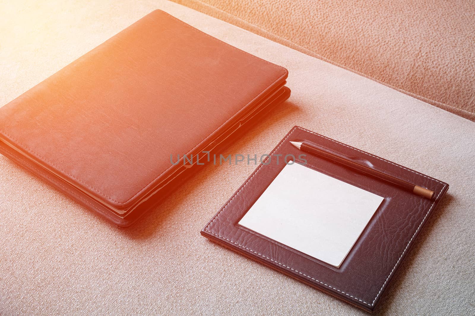 Black leather note book with pencil on carpet background