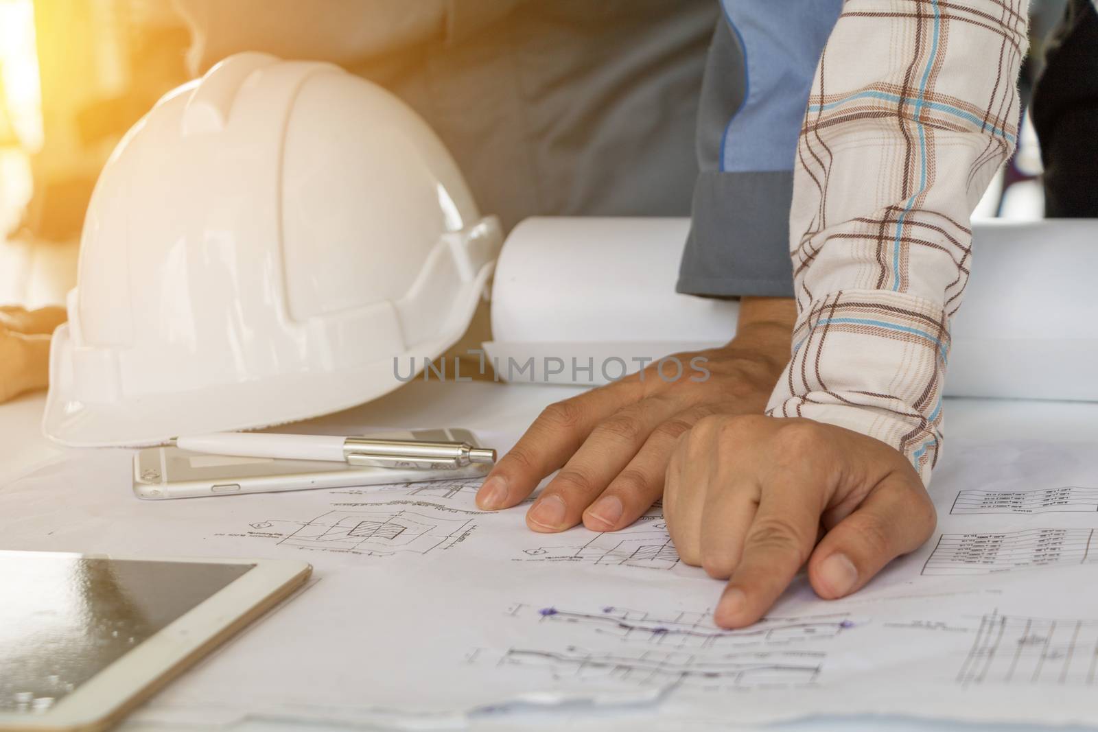 A group of engineers are looking at a blueprint for construction by minamija
