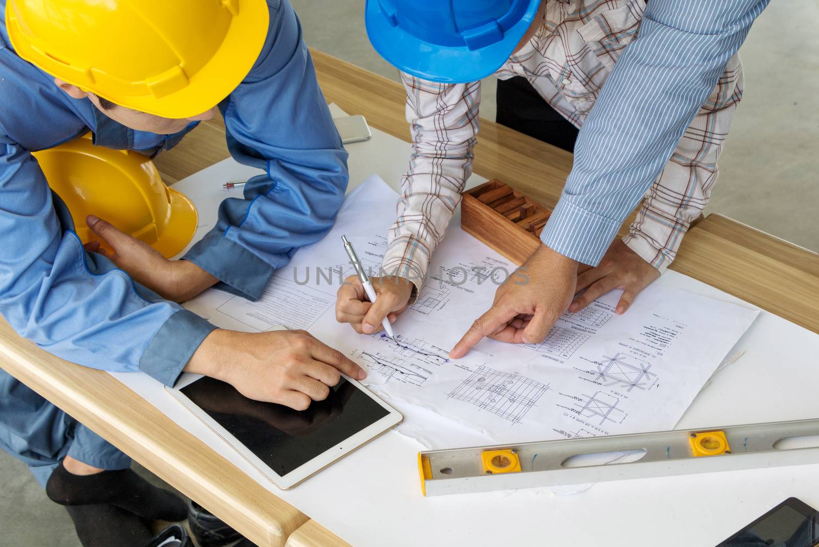 A group of engineers are looking at a blueprint for construction on the table. Engineering concept.