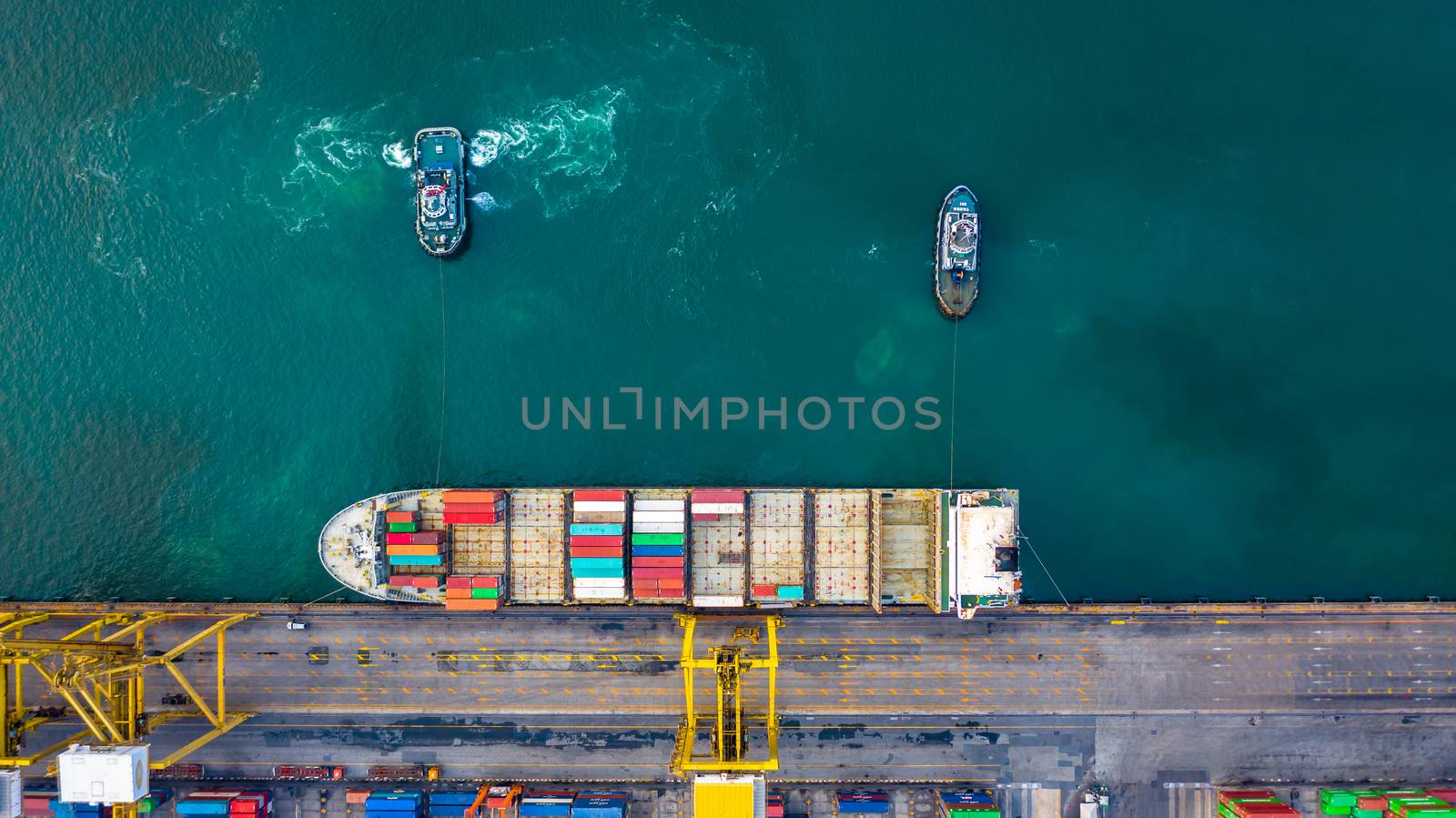 Aerial top view container ship at terminal seaport with tugboat, Global business cargo freight ship import export logistic and transportation by container vessel ship company worldwide.