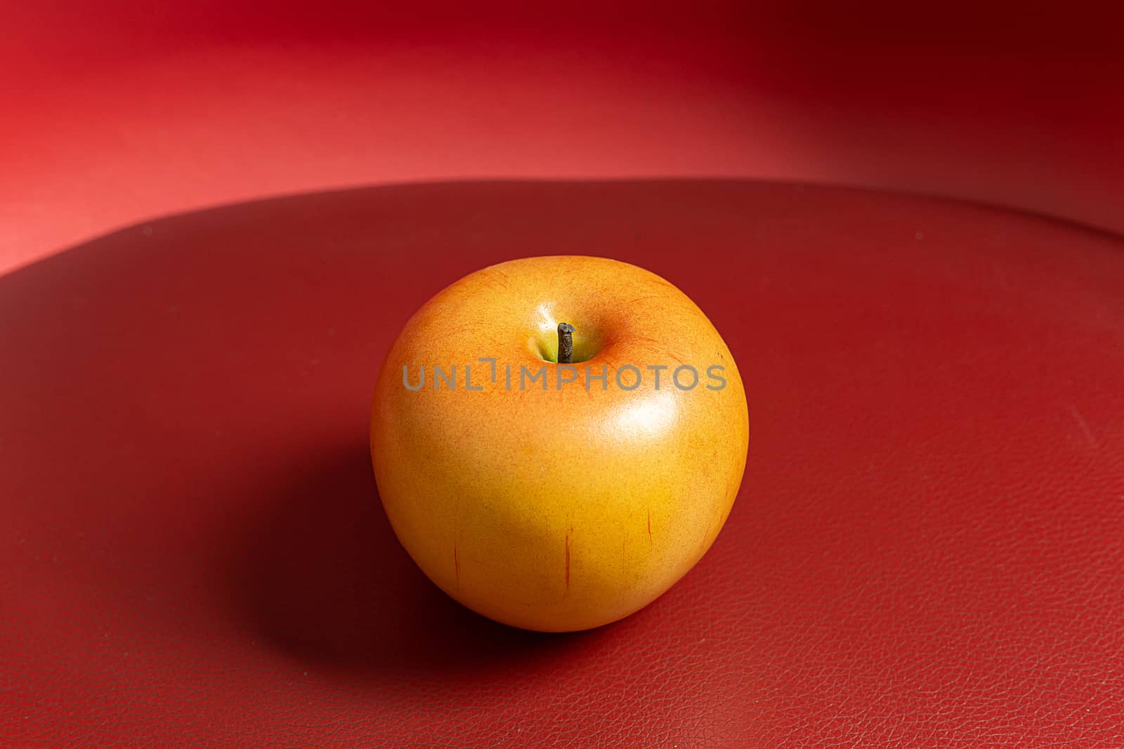 A apple on red background low light for food content.
