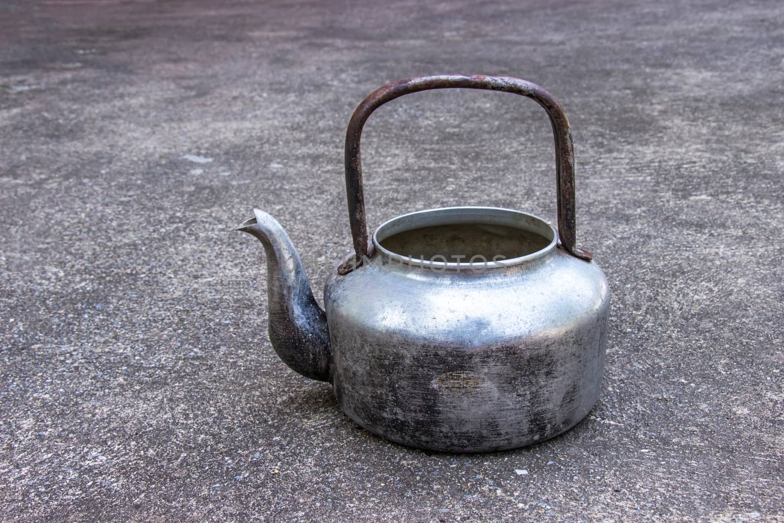 Classic old Kettle at put on concrete background.